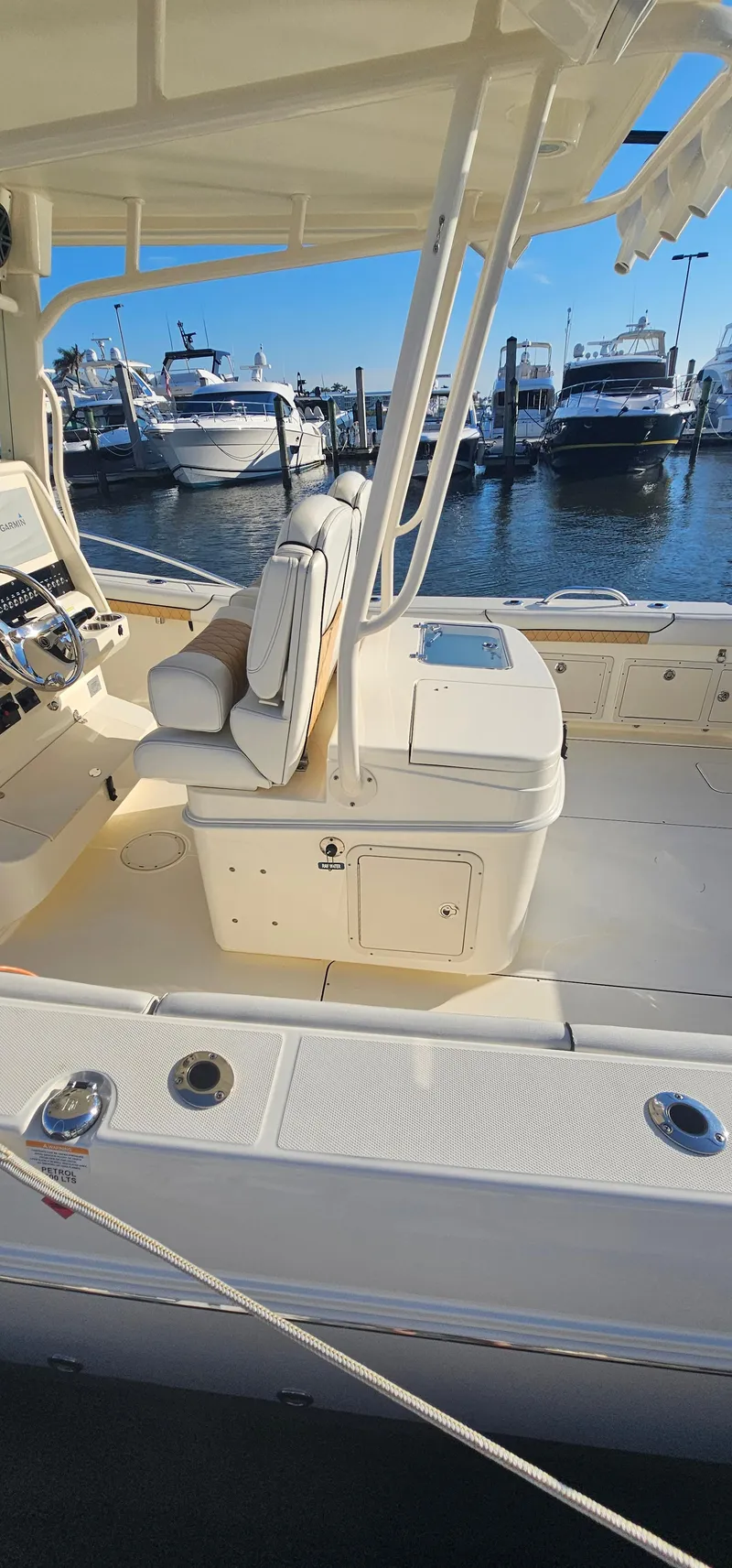 Slide: The Image of 2016 World Cat 320 boat interior at marina, featuring seating and control panel. - 23