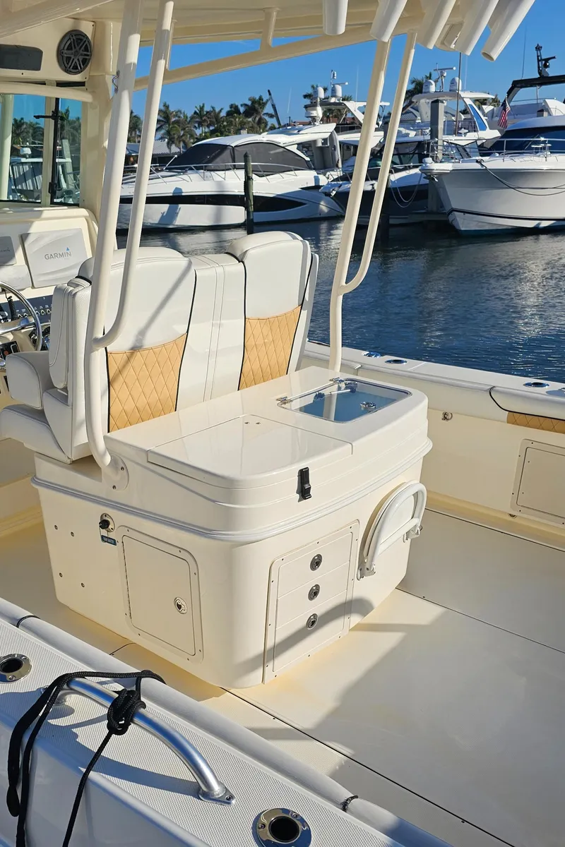 Slide: The Image of 2016 World Cat 320 boat interior with seating and storage, docked at a marina. - 26