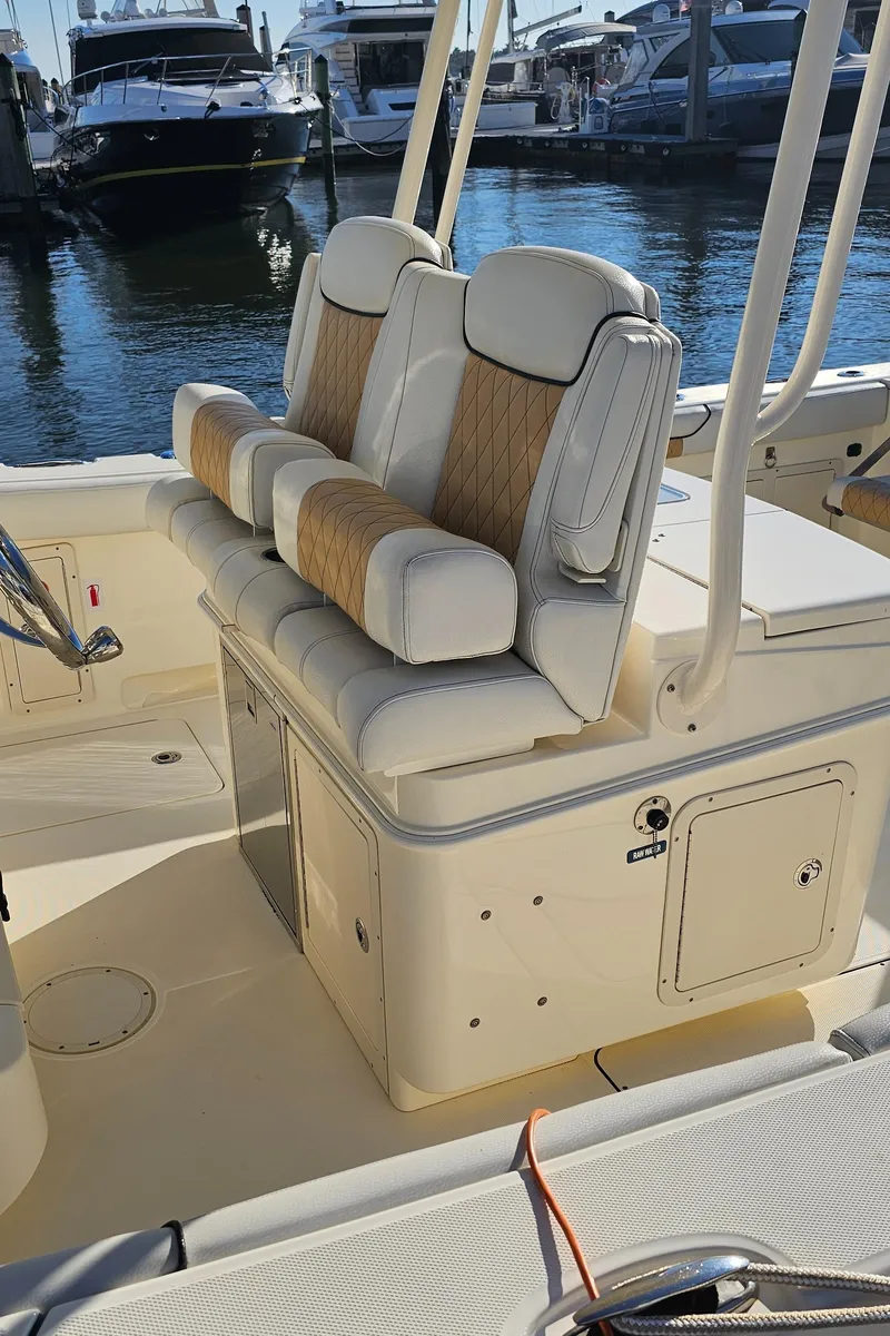 Slide: The Image of 2016 World Cat 320 boat seating area with cushioned seats, docked at marina. - 29