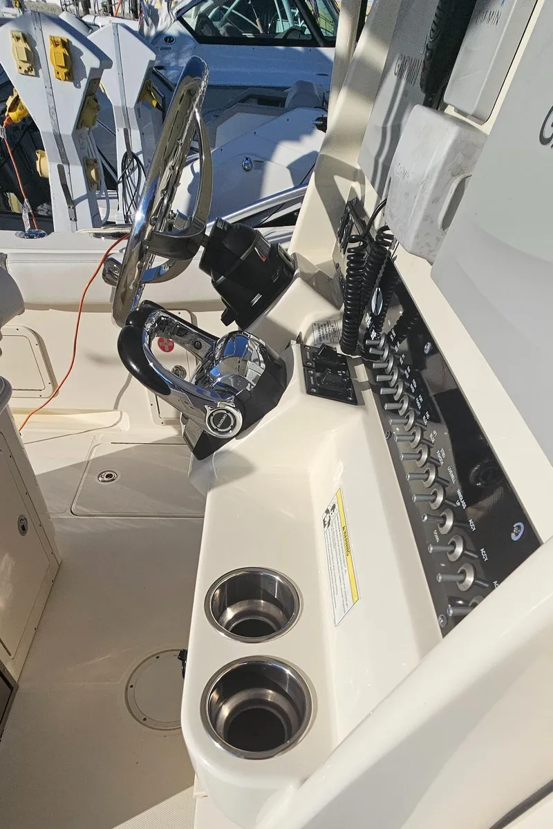 Slide: The Image of 2016 World Cat 320 boat cockpit with steering wheel and control panel. - 33