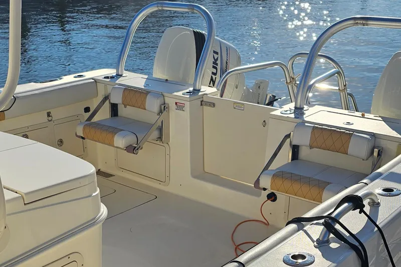 Slide: The Image of 2016 World Cat 320 boat interior with Suzuki engines, featuring seating and railing. - 8