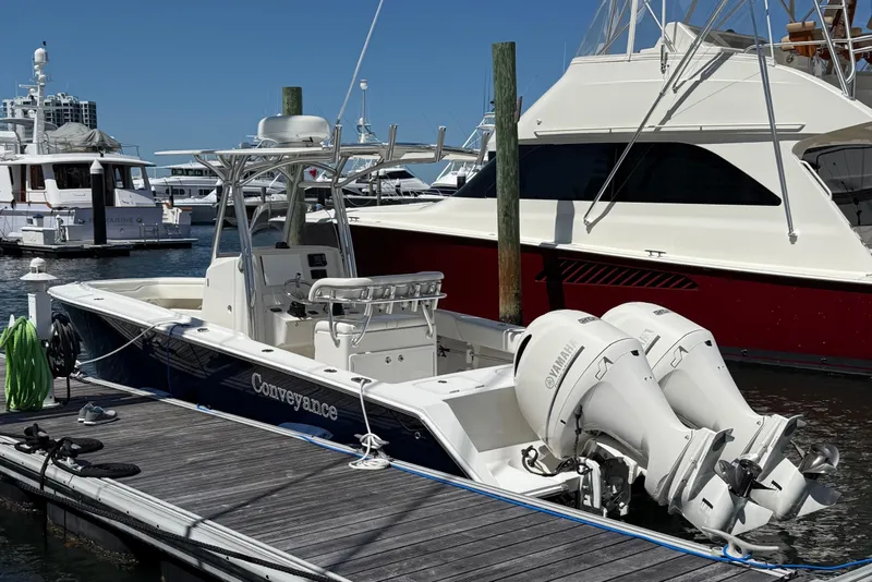 Slide: The Image of 2014 Jupiter 26CC boat docked with twin outboard engines in a marina. - 18