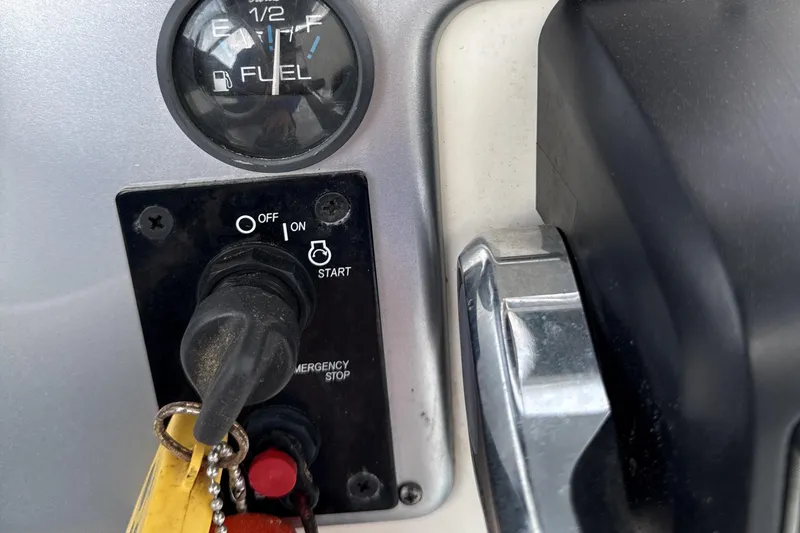 Slide: The Image of 2008 Carolina Skiff 238 DLV ignition panel with fuel gauge and emergency stop switch. - 12
