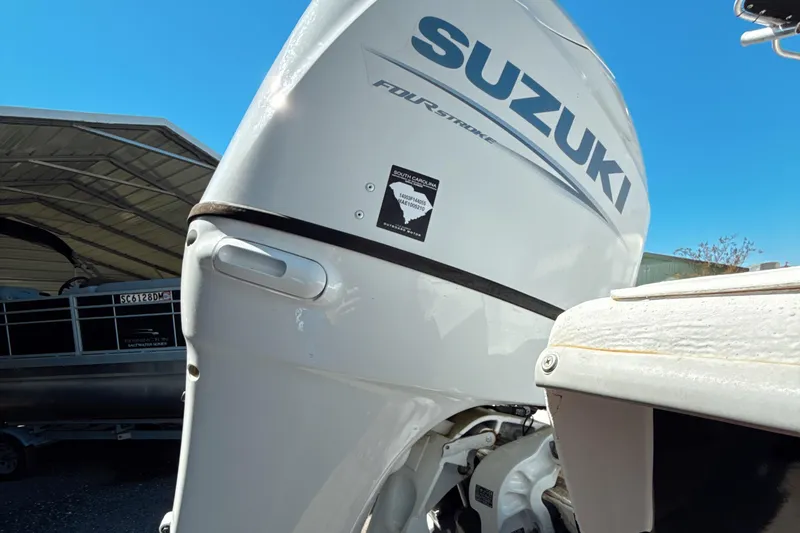 Slide: The Image of 2008 Carolina Skiff 238 DLV with Suzuki outboard motor, under clear blue sky. - 6