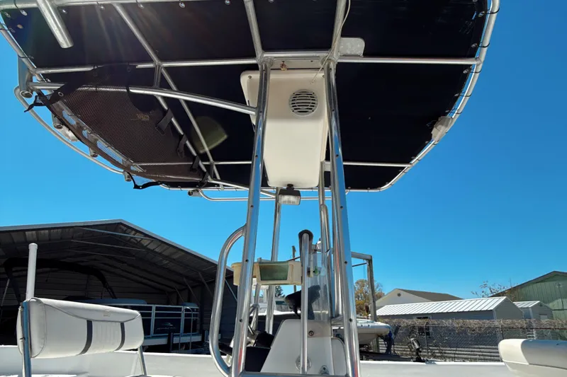 Slide: The Image of 2008 Carolina Skiff 238 DLV boat with T-top, parked under clear blue sky. - 8