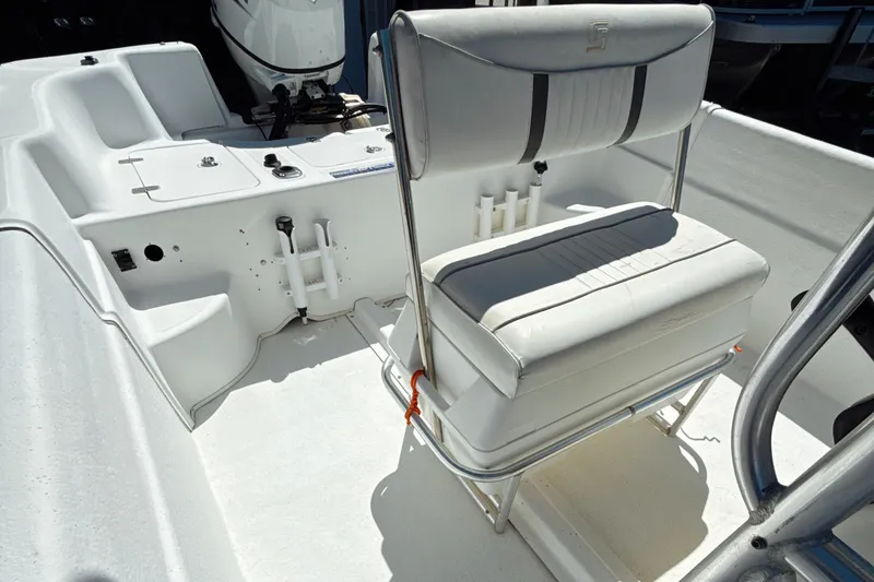 Slide: The Image of 2008 Carolina Skiff 238 DLV boat interior with white seating and motor. - 9