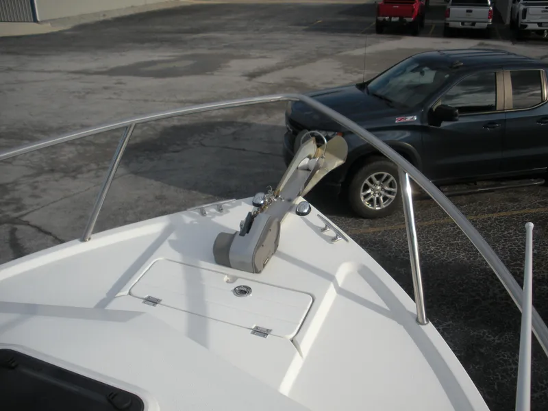 Slide: The Image of 2018 Parker 2120 Sport Cabin boat bow with anchor, parked near a black truck. - 2