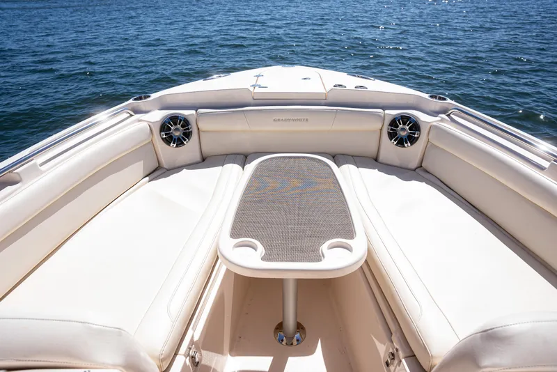 Slide: The Image of 2020 Grady-White Freedom 285 boat interior with cushioned seating and table on open water. - 13