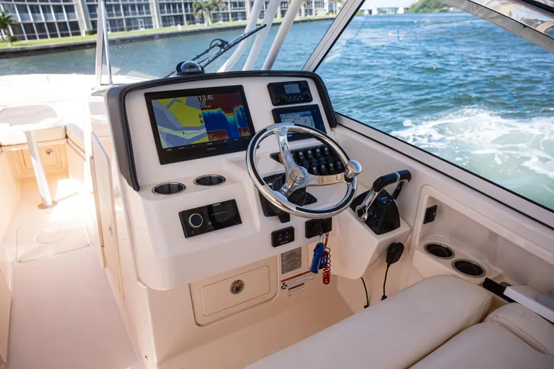 Slide: The Image of 2020 Grady-White Freedom 285 boat dashboard with navigation system and steering wheel. - 17