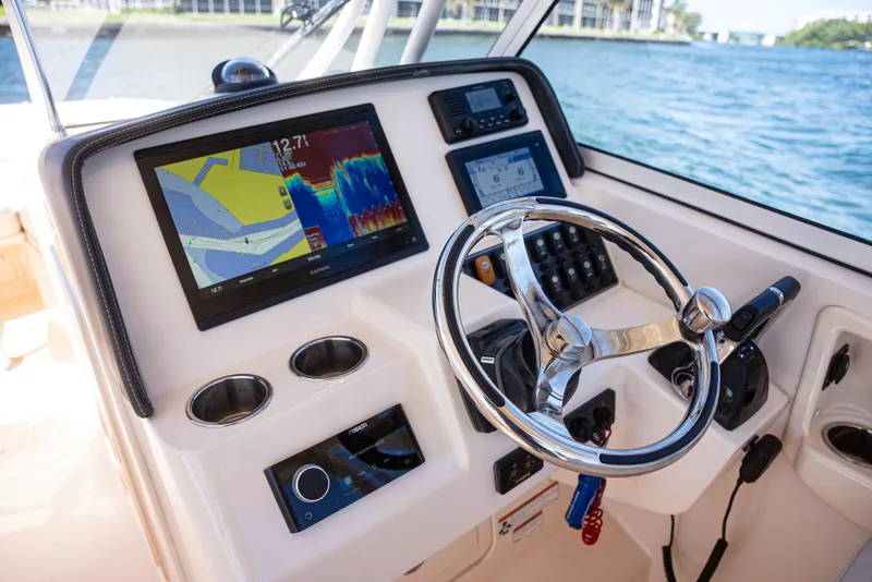 Slide: The Image of 2020 Grady-White Freedom 285 boat dashboard with navigation screens and steering wheel. - 18