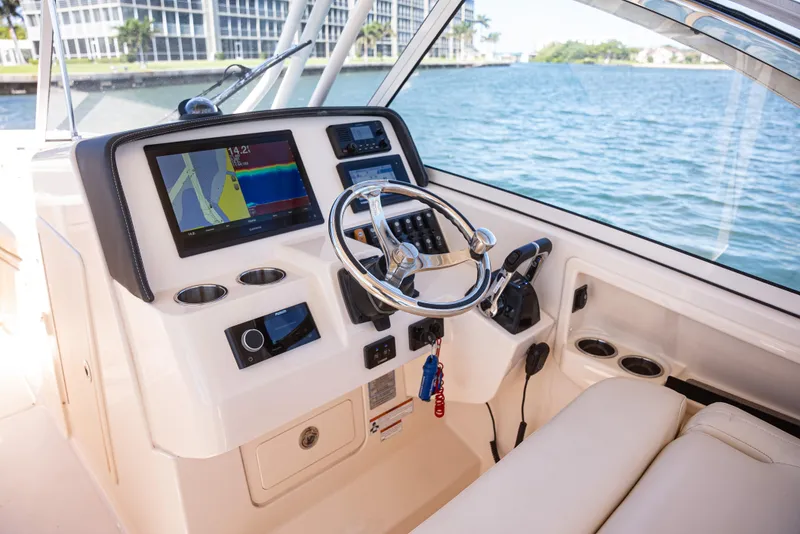 Slide: The Image of 2020 Grady-White Freedom 285 boat dashboard with navigation system and steering wheel. - 21
