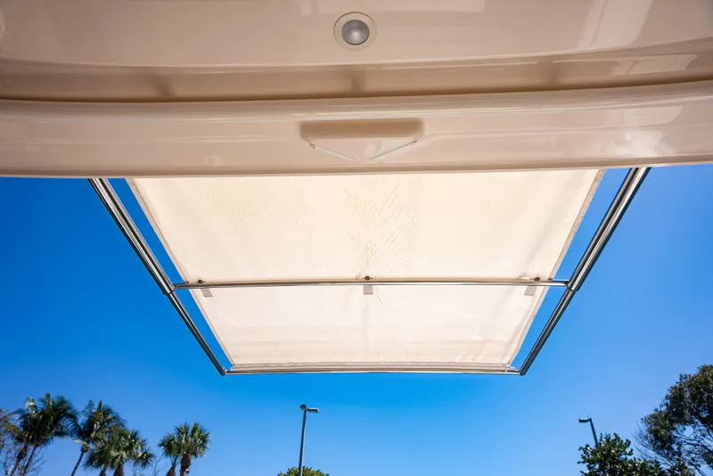 Slide: The Image of 2020 Grady-White Freedom 285 boat canopy against clear blue sky and palm trees. - 31