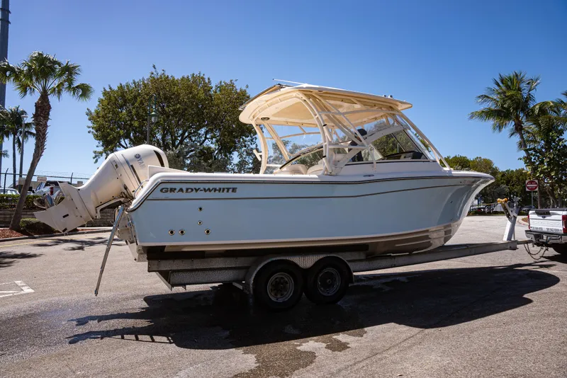 Slide: The Image of 2020 Grady-White Freedom 285 boat on trailer, parked under clear blue sky. - 32