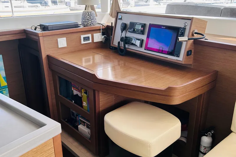 Slide: The Image of Navigation station in 2019 Lagoon 450 F Owner's Edition yacht, featuring modern equipment and wooden finish. - 20