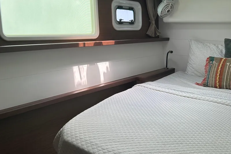 Slide: The Image of Cozy bedroom in 2019 Lagoon 450 F Owner's Edition yacht with window and bedding. - 29