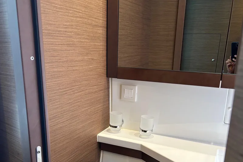 Slide: The Image of 2019 Lagoon 450 F Owner's Edition bathroom with modern fixtures and wood paneling. - 42