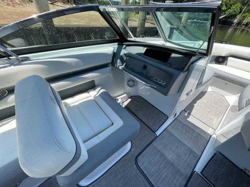 Slide: The Image of 2018 Cobalt CS22 boat interior with gray seating and dashboard, featuring open windshield. - 10