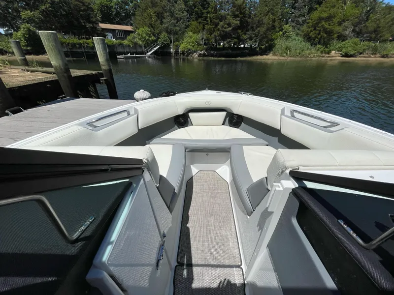 Slide: The Image of 2018 Cobalt CS22 boat interior with white seating, docked by a serene lake. - 11
