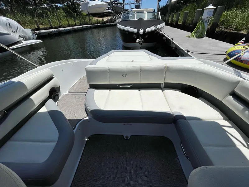 Slide: The Image of 2018 Cobalt CS22 boat interior with white seating, docked near a wooden pier. - 5