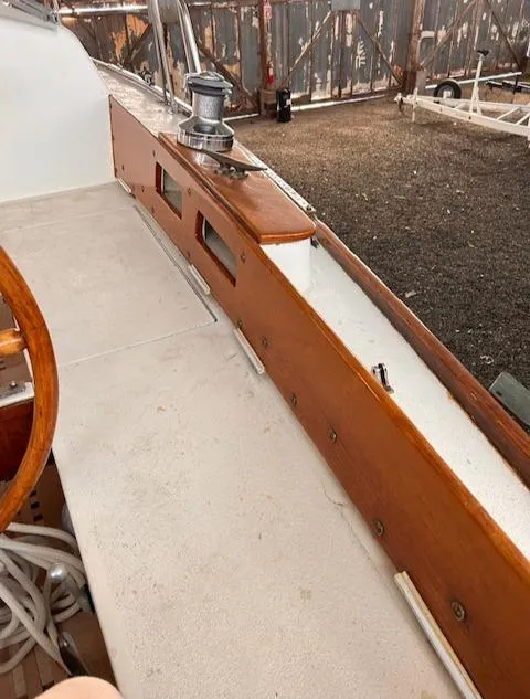 Slide: The Image of 1972 Bristol 40 sailboat deck with wooden trim and winch, docked in a yard. - 10