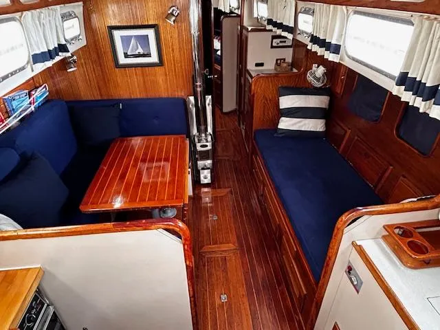 Slide: The Image of 1972 Bristol 40 yacht interior with wooden finish, blue seating, and nautical decor. - 16