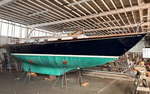 Slide: The Image of 1972 Bristol 40 sailboat in a workshop, elevated on stands for maintenance. - 2
