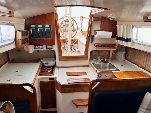 Slide: The Image of Interior of a 1972 Bristol 40 sailboat featuring a compact kitchen and navigation area. - 22