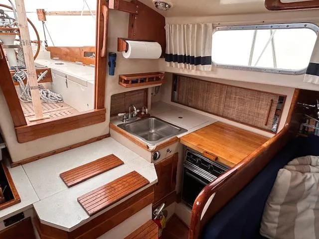 Slide: The Image of 1972 Bristol 40 yacht interior with compact kitchen, wooden cabinetry, and stainless steel sink. - 24