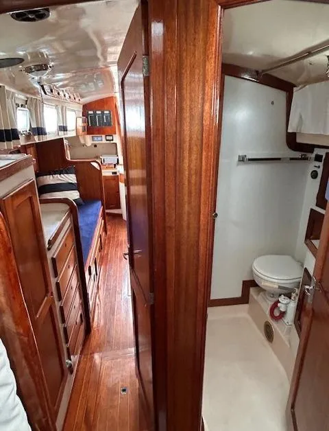 Slide: The Image of Interior of a 1972 Bristol 40 sailboat featuring wood paneling, a cozy cabin, and a compact bathroom. - 31