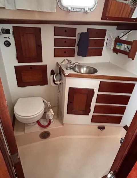 Slide: The Image of 1972 Bristol 40 yacht bathroom with wooden cabinets, sink, and toilet. - 33