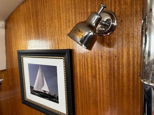Slide: The Image of Wood-paneled interior of a 1972 Bristol 40 yacht with framed sailboat photo and chrome light fixture. - 35