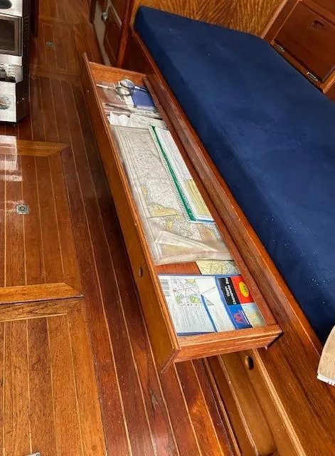 Slide: The Image of 1972 Bristol 40 interior with wooden flooring, open drawer, and nautical charts. - 36