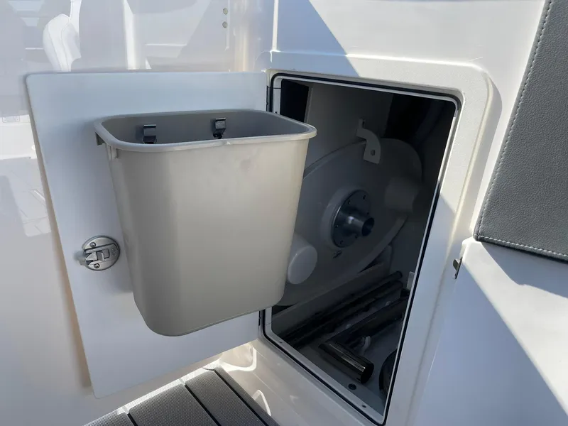 Slide: The Image of Interior storage compartment of 2025 Chaparral 270 OSX boat with trash bin. - 29