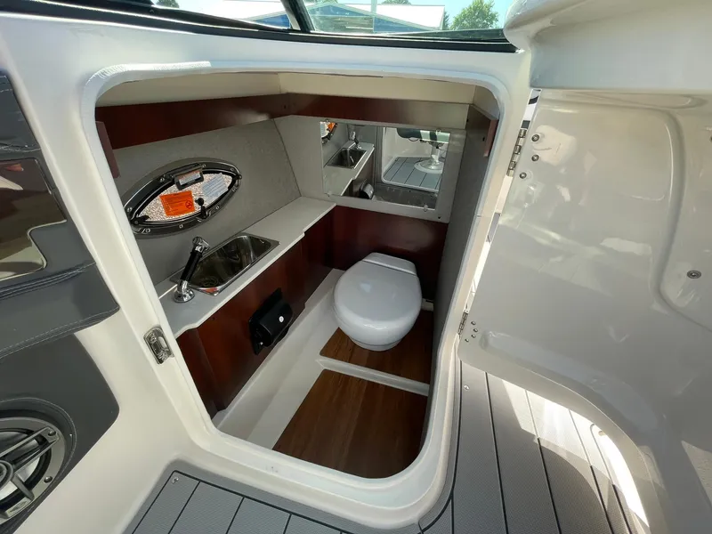 Slide: The Image of 2025 Chaparral 270 OSX boat interior with compact bathroom and sink. - 40