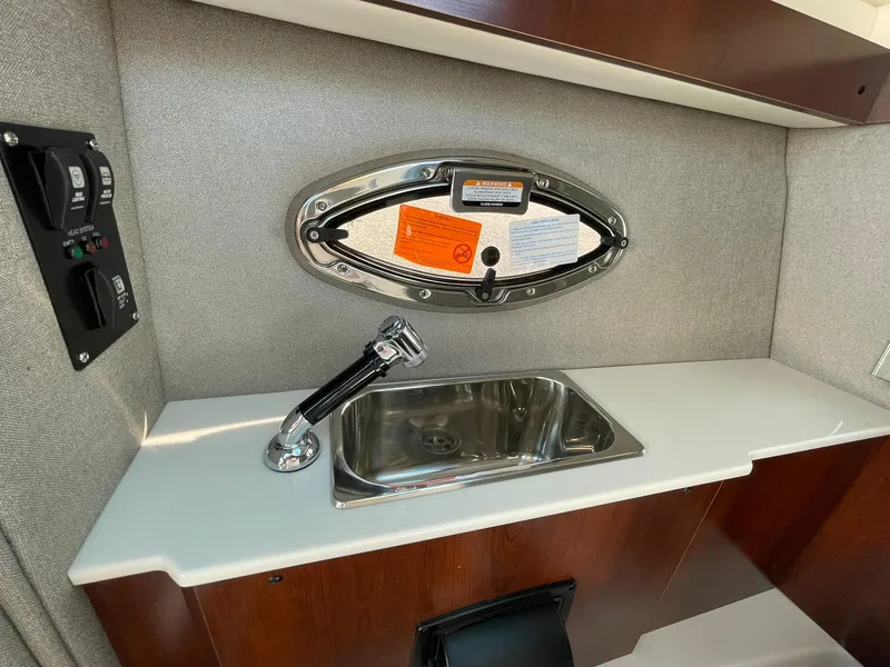 Slide: The Image of 2025 Chaparral 270 OSX boat interior with sink and porthole window. - 43