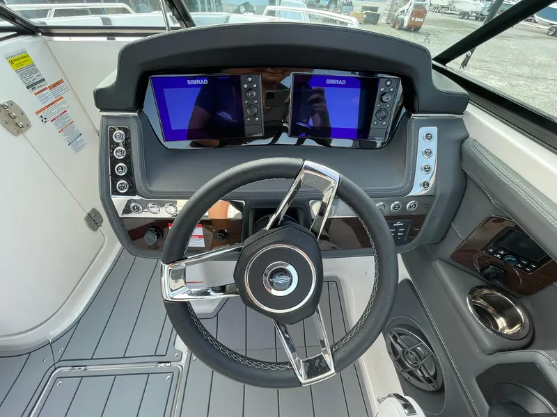 Slide: The Image of 2025 Chaparral 270 OSX boat dashboard with dual Simrad displays and modern steering wheel. - 25