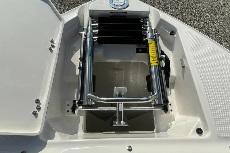 Slide: The Image of 2025 Chaparral 270 OSX boat anchor compartment with ladder, open hatch view. - 6