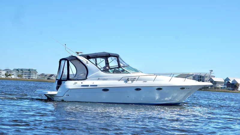 Slide: The Image of 2003 Cruisers Yachts 3372 Express on calm water under clear blue sky. - 3