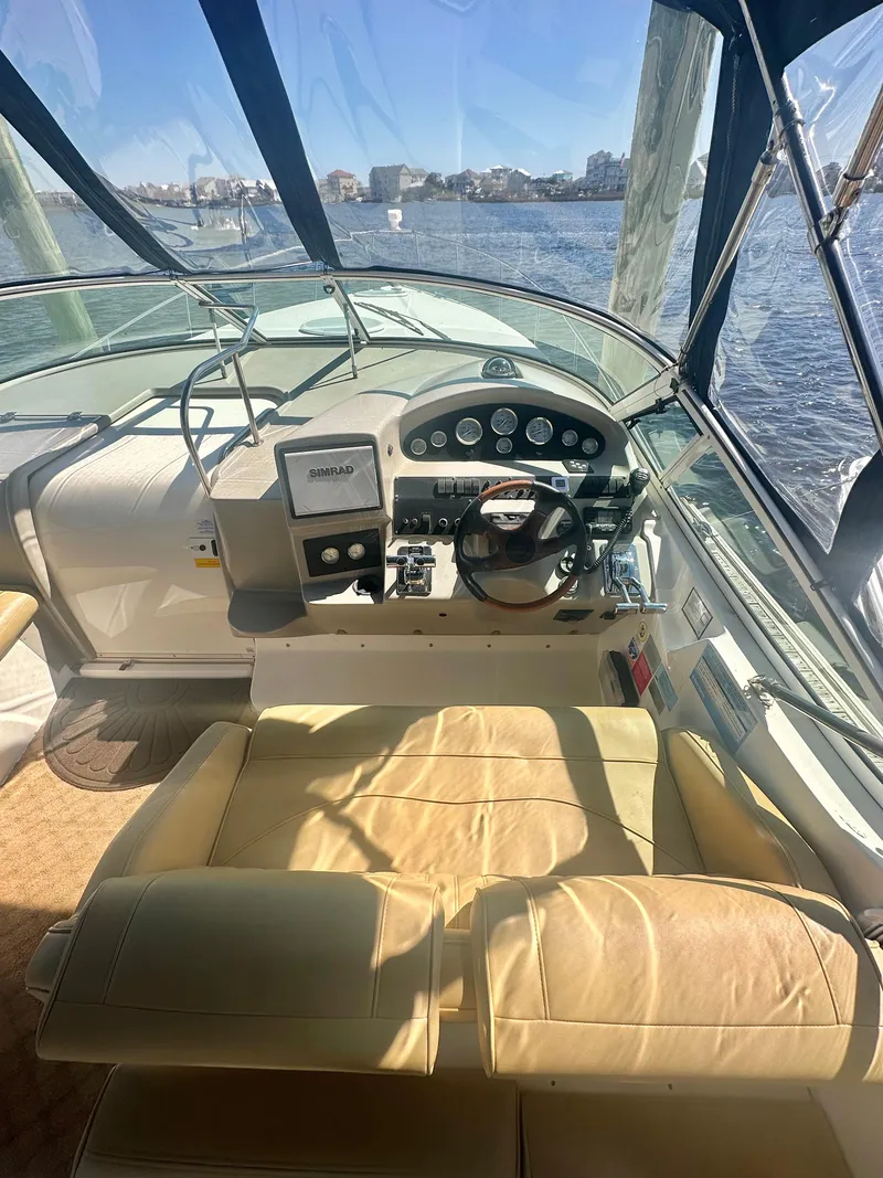 Slide: The Image of 2003 Cruisers Yachts 3372 Express cockpit with steering wheel and dashboard, overlooking water. - 5