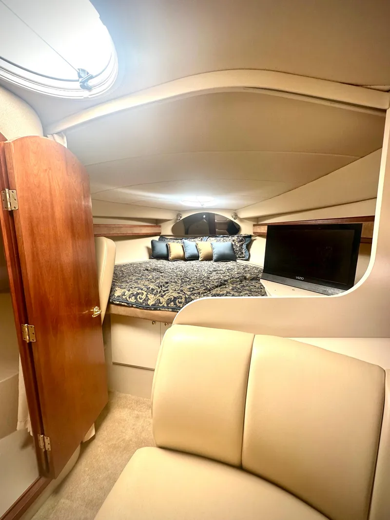 Slide: The Image of 2003 Cruisers Yachts 3372 Express cabin interior with bed, TV, and seating. - 7