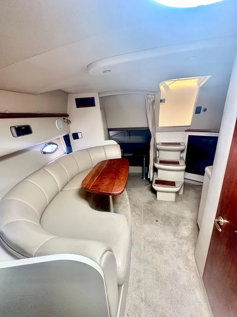 Slide: The Image of 2003 Cruisers Yachts 3372 Express interior with curved seating and wooden table. - 9