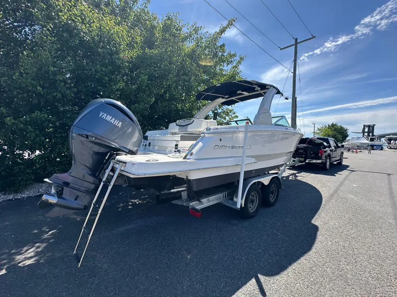 Slide: The Image of 2023 Chaparral 270 OSX boat on trailer with Yamaha outboard motor, parked outdoors. - 11