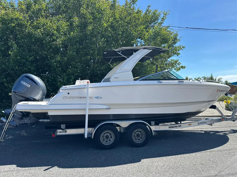 Slide: The Image of 2023 Chaparral 270 OSX boat on trailer with Yamaha engine, parked outdoors. - 2