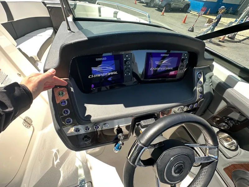 Slide: The Image of 2023 Chaparral 270 OSX dashboard with dual Simrad displays and steering wheel. - 26