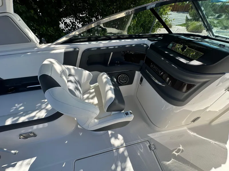 Slide: The Image of 2023 Chaparral 270 OSX boat cockpit with modern helm and comfortable seating. - 27