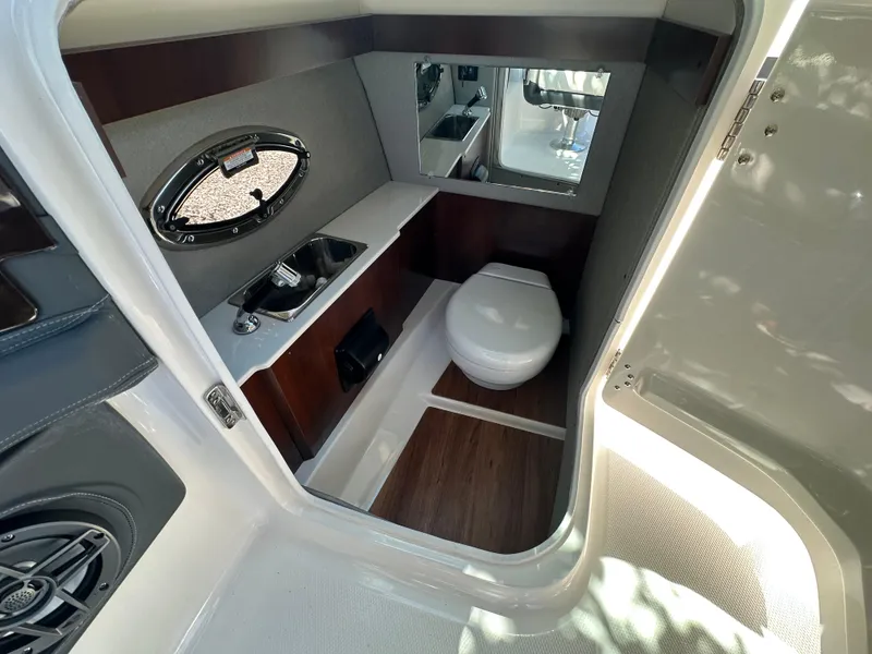Slide: The Image of 2023 Chaparral 270 OSX boat interior with sink and toilet, featuring modern design. - 31