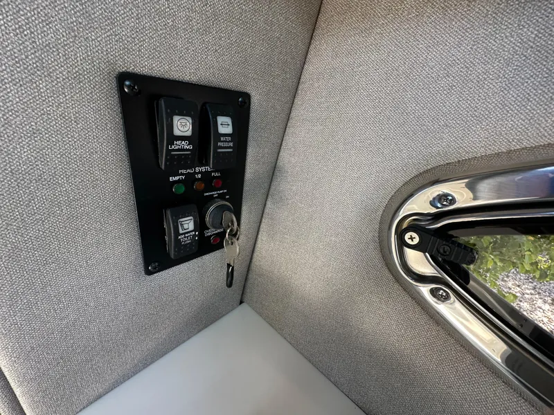 Slide: The Image of Control panel in 2023 Chaparral 270 OSX boat interior, featuring key ignition and switches. - 32