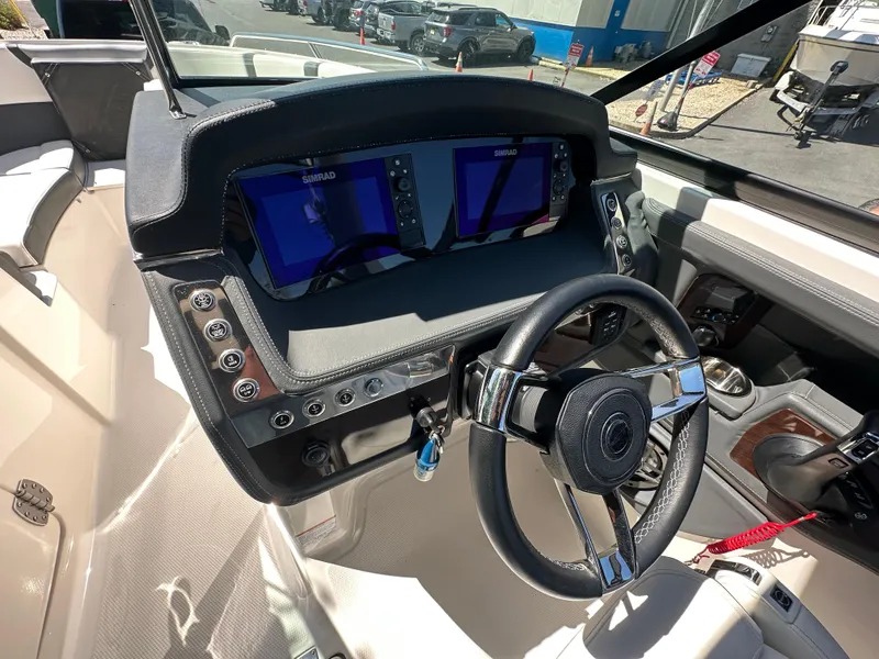 Slide: The Image of 2023 Chaparral 270 OSX boat dashboard with dual Simrad displays and steering wheel. - 35