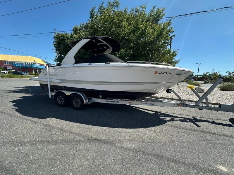 Slide: The Image of 2023 Chaparral 270 OSX boat on trailer, parked outdoors on a sunny day. - 48