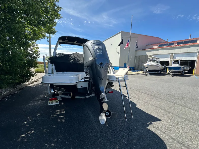 Slide: The Image of 2023 Chaparral 270 OSX boat with 300 HP engine, parked outdoors near a marina. - 49